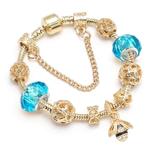 Gouden slangenketting armband met blauwe kristallen kralen en bijen hanger