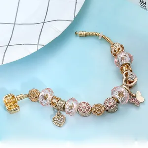 Bracciale a catena serpente dorata con perle di cristallo rosa e ciondoli a cuore