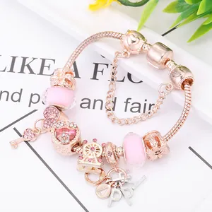 Bracciale in oro rosa con ciondoli a cuore e chiave, perline rosa e cristalli lucidi