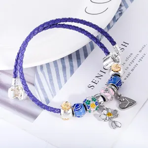 Blue braided leather charm bracelet with floral enamel beads and silver butterfly pendants