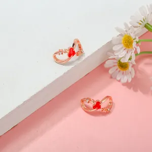 Detail eines Roségold-Infinity-Rings mit rotem Herz und Kristallen auf zweifarbigem Grund