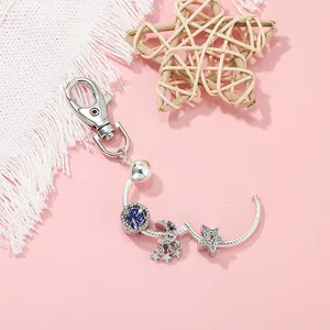 Dettaglio dei ciondoli a stella e luna argentati con cristalli blu su catena con moschettone