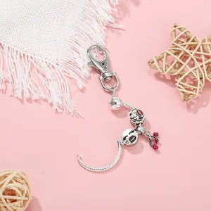 Detail of silver snake chain keychain with red heart charm and colorful enamel beads