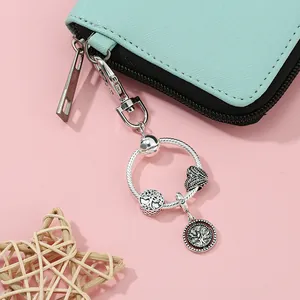 Dettaglio dei ciondoli albero della vita in argento e cuore su pochette in pelle blu