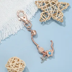 Detail of rose gold keychain with butterfly charm and blue crystal on snake chain