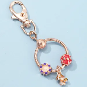 Detail of rose gold key ring with mushroom charm, purple flower ball and hollow bead
