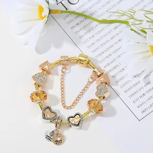 Golden Pandora-style charm bracelet with amber crystal beads and heart-shaped pendants