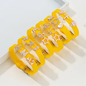 Yellow silicone wristband with rose gold charms featuring star and tree of life motifs