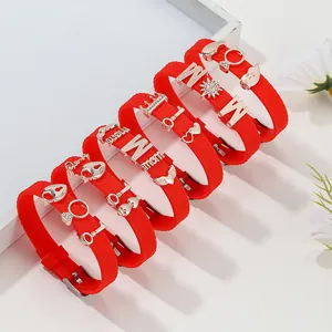 Set of 6 red silicone bracelets with gold charms including MOM letters and crown