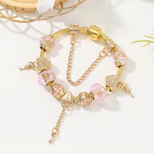 Goldenes DIY Charm-Armband mit rosa Kristallperlen und Herzschloss-Anhänger auf weißem Grund