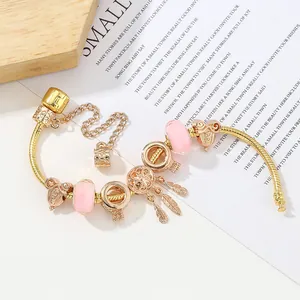 Bracciale a serpente dorato con perline di vetro rosa e ciondolo a piuma dorata