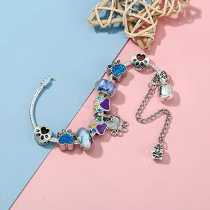 Bedelarmband met hondenpootje met blauw hart en paarse kralen op zilveren slangenketting