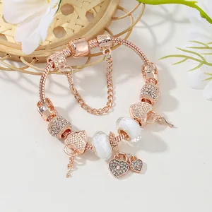 Bracelet à breloques en or rose avec pendentifs coeur étincelants et chaîne serpent