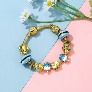 Gouden slangenketting armband met blauw ijsje en vliegtuigbedels op kleurrijke achtergrond