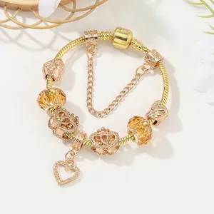 Pulsera de dijes dorada con cuentas de corona, cristales ámbar y colgante de corazón en cadena