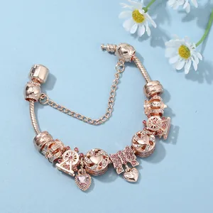 Rose gold ferris wheel charm bracelet with pink crystals and heart pendants on blue background