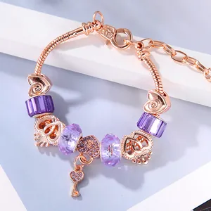 Pulsera de oro rosa con cuentas de cristal violeta y colgante de llave de corazón