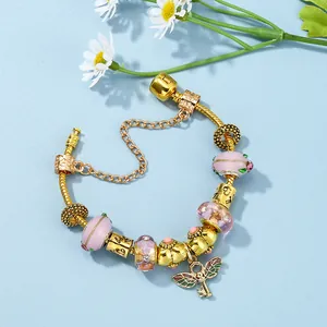 Bracciale a serpente dorato con perline di vetro rosa e ciondolo a chiave con ali