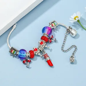Bracciale con ciondoli argento con rossetto rosso e bicchiere di vino su sfondo blu