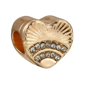 Charm a cuore dorato con scanalature radianti e strass di cristallo scintillanti