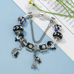 Pulsera de cuentas con colgantes de Torre Eiffel y cámara sobre fondo azul