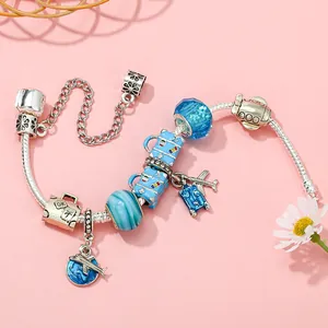 Travel themed silver snake chain bracelet with airplane and blue luggage charms