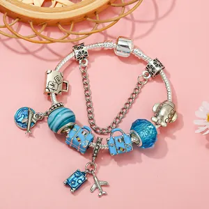 Travel themed silver snake chain bracelet with blue glass beads and airplane luggage charms