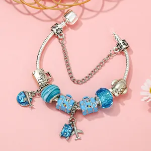 Travel themed charm bracelet with airplane luggage charms and blue glass beads on snake chain
