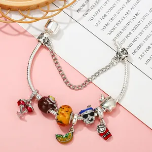 Silbernes Perlenarmband mit Kirsch-, Soda- und Pommes-Anhängern auf rosa-weißem Hintergrund