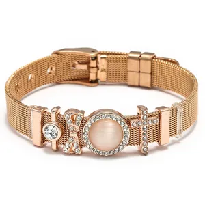 Pulsera de malla oro rosa con dijes de cruz de cristal y piedra ojo de gato rosa