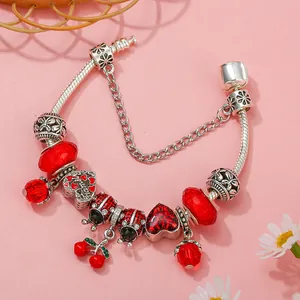 Silver snake chain bracelet featuring red cherry, ladybug charms and a safety chain