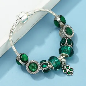 Silver charm bracelet with green emerald beads and a lucky four-leaf clover pendant