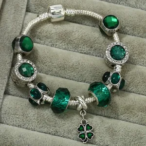 Detail of emerald green faceted beads and lucky clover pendant on a silver snake chain