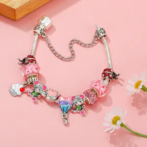 Silver snake chain bracelet with colorful beads, bear and birthday charms on pink background