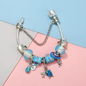Travel themed charm bracelet with blue glass beads, airplane and suitcase pendants