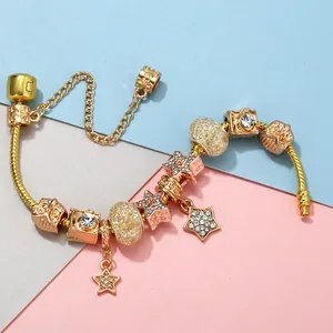 Vue détaillée du bracelet doré avec des breloques étoiles et pendentifs appareil photo