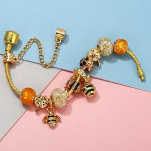 Close-up of S925 hallmark on golden bee charm bracelet with honey-themed beads