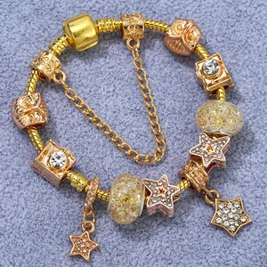 Bracelet chaîne serpent doré avec breloques hibou, appareil photo et étoile sur tissu