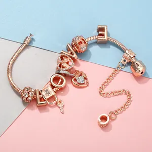Detail eines Roségold-Bettelarmbands mit LOVE-Buchstaben, Herzschloss und Schlüsselanhänger