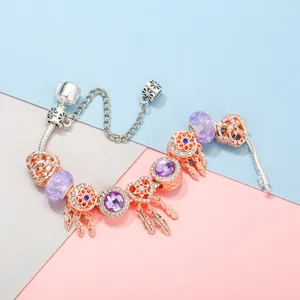 Bracelet à breloques en or rose avec cristaux violets et pendentif plume attrape-rêve