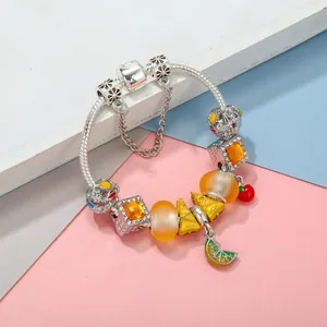 Tropical style charm bracelet with orange glass beads and lemon fruit charms on snake chain