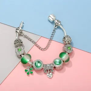 Silver snake chain bracelet with green crystal beads and lucky clover charms
