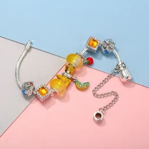 DIY charm bracelet with yellow glass beads and lemon enamel pendants on snake chain