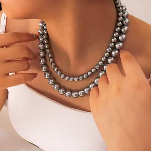Primer plano de un collar de perlas grises de doble capa con brillo metálico en modelo