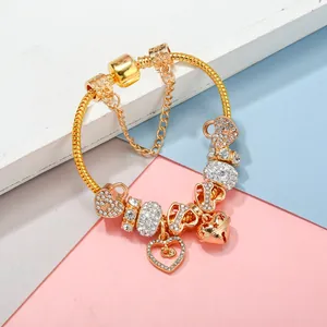Bracelet à chaîne serpent dorée avec cristaux blancs et pendentifs coeur sur fond géométrique