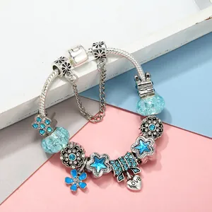 DIY bedelarmband met blauwe bloemkralen, strasstrik en hartvormige hanger met Love tekst