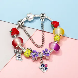 Colorful charm bracelet with crown pendant and strawberry beads on silver snake chain