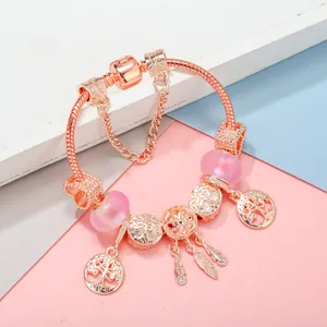 Bracelet maille serpent en or rose avec perles roses, arbre de vie et charmes attrape-rêves