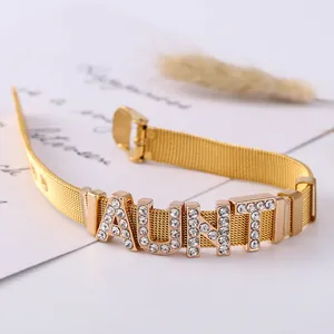 Detail of golden mesh bracelet with rhinestone AUNT letters and watchband style buckle