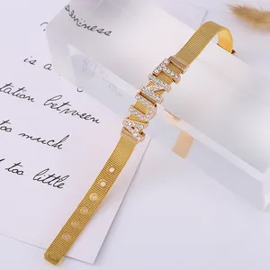 Detail of golden stainless steel mesh bracelet with sparkling AUNTIE rhinestone letters